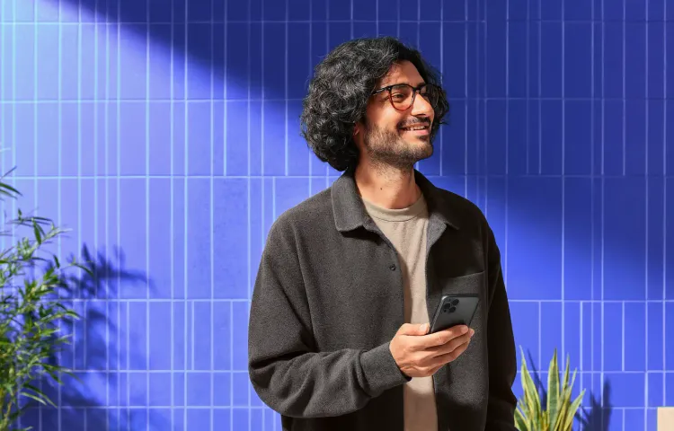 Persona usando su celular para comparar distintas criptomonedas