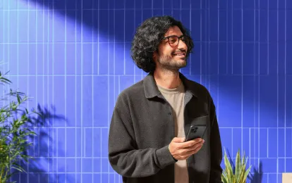 Persona usando su celular para comparar distintas criptomonedas